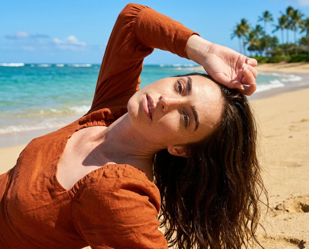 Woman lying on a sunny tropical beach with turquoise water behind her after an AI photo editor background change